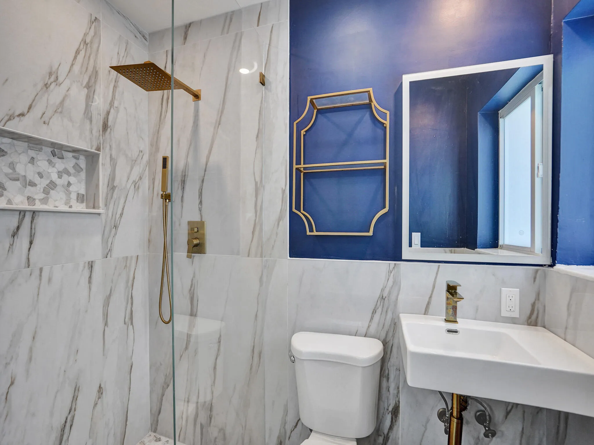 Primary bath with gold trim hardware and standing shower