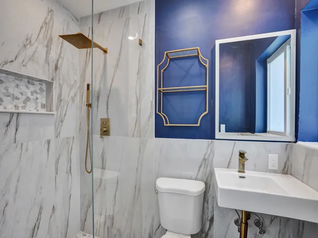 Primary bath with gold trim hardware and standing shower