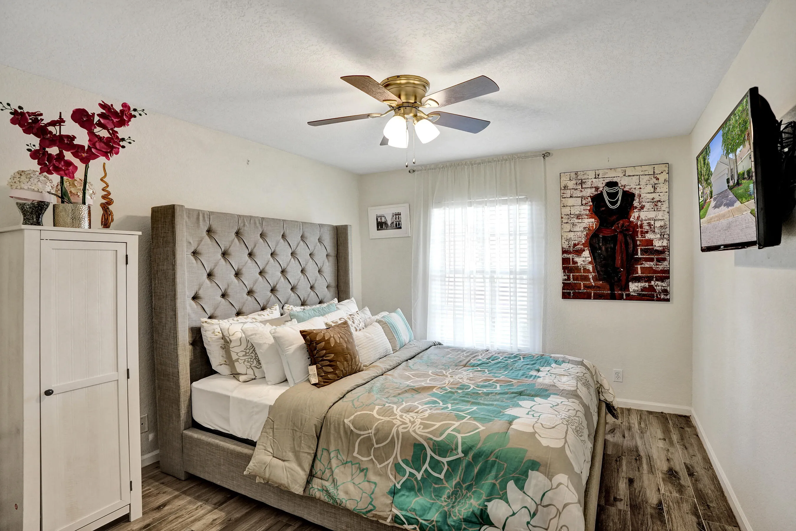 Bedroom 3: A comfortable, light-filled retreat with wood-look tile flooring and a relaxed, welcoming feel.