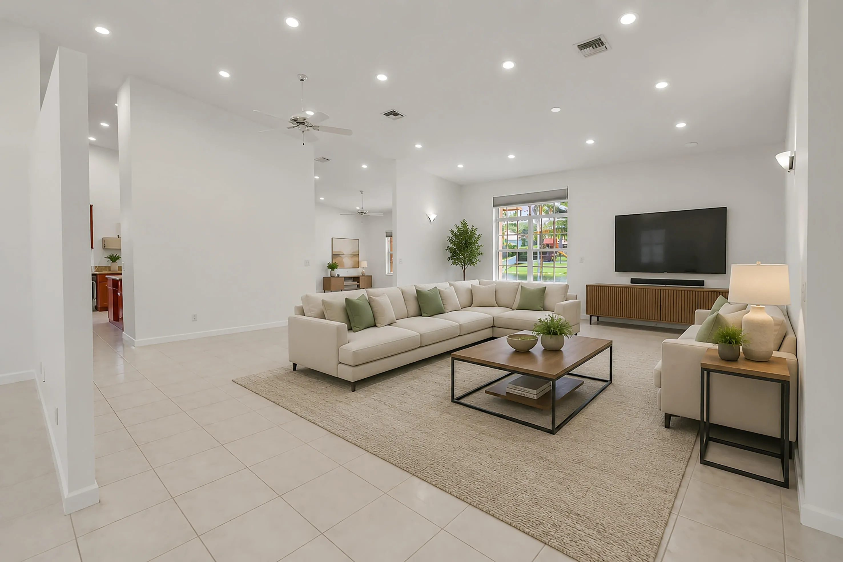 Spacious living area featuring neutral tile flooring, recessed lighting, and a ceiling fan