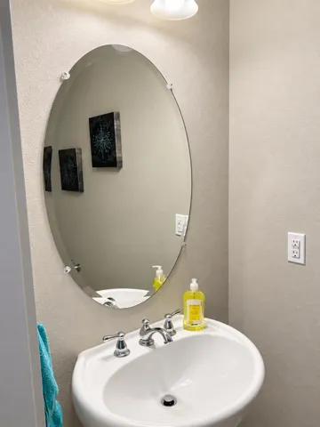 Bathroom vanity with oval mirror.