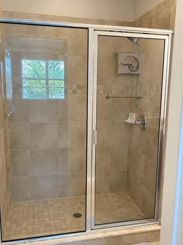 Enclosed walk-in shower with glass doors.
