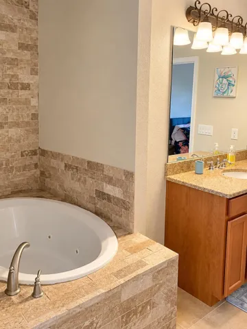 Bathroom featuring soaking tub and vanity.