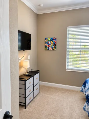 Furnished bedroom with window and natural light.