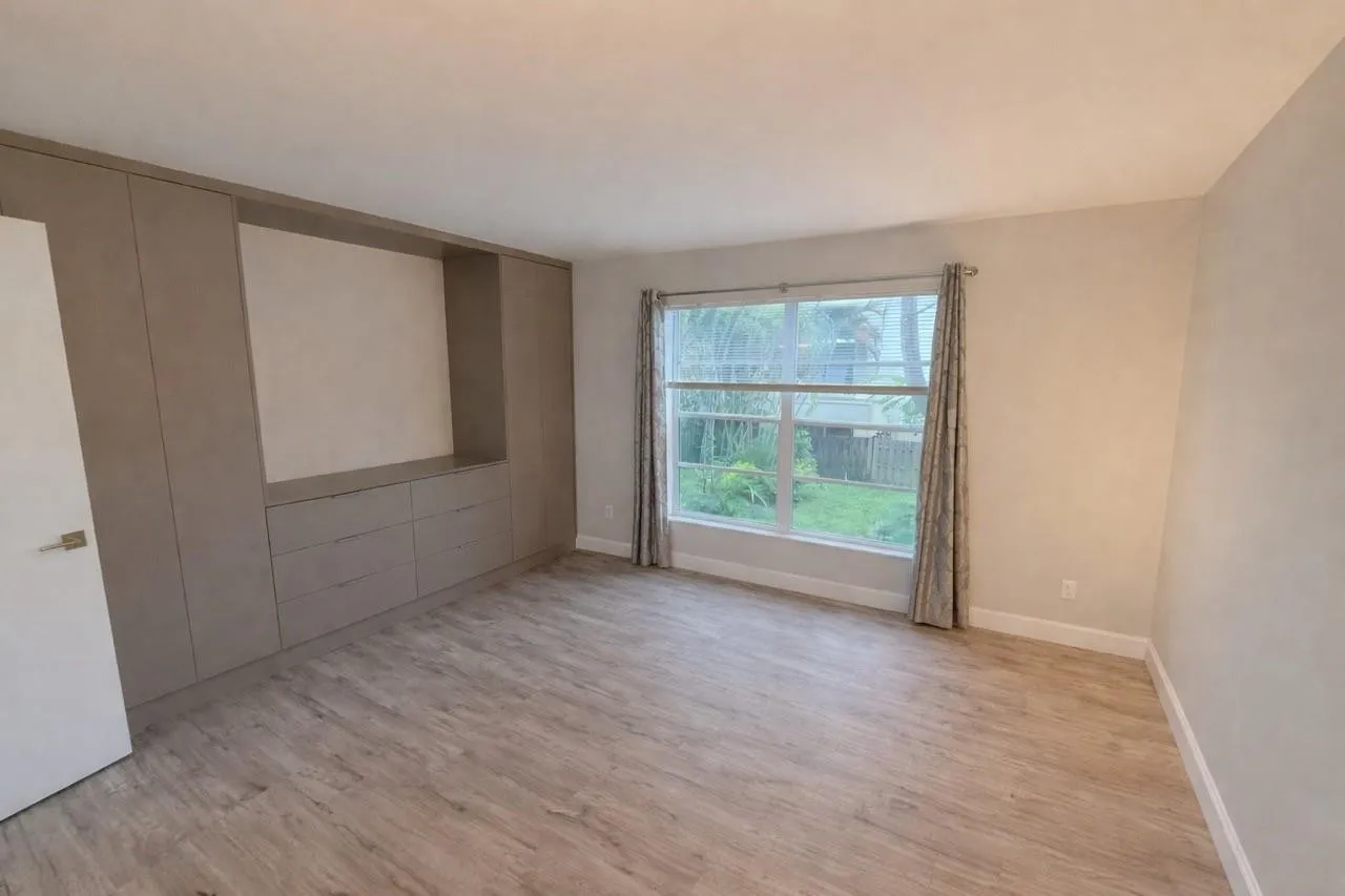 Built-in cabinetry with integrated drawers, wood-finish flooring, and a large window