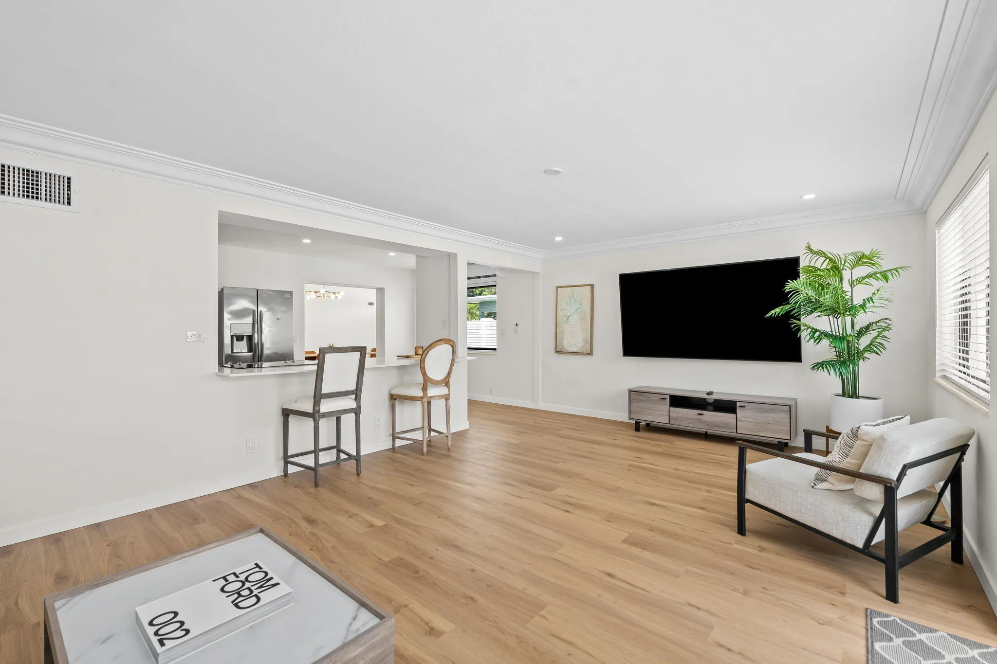 Light wood-finish flooring with white crown molding