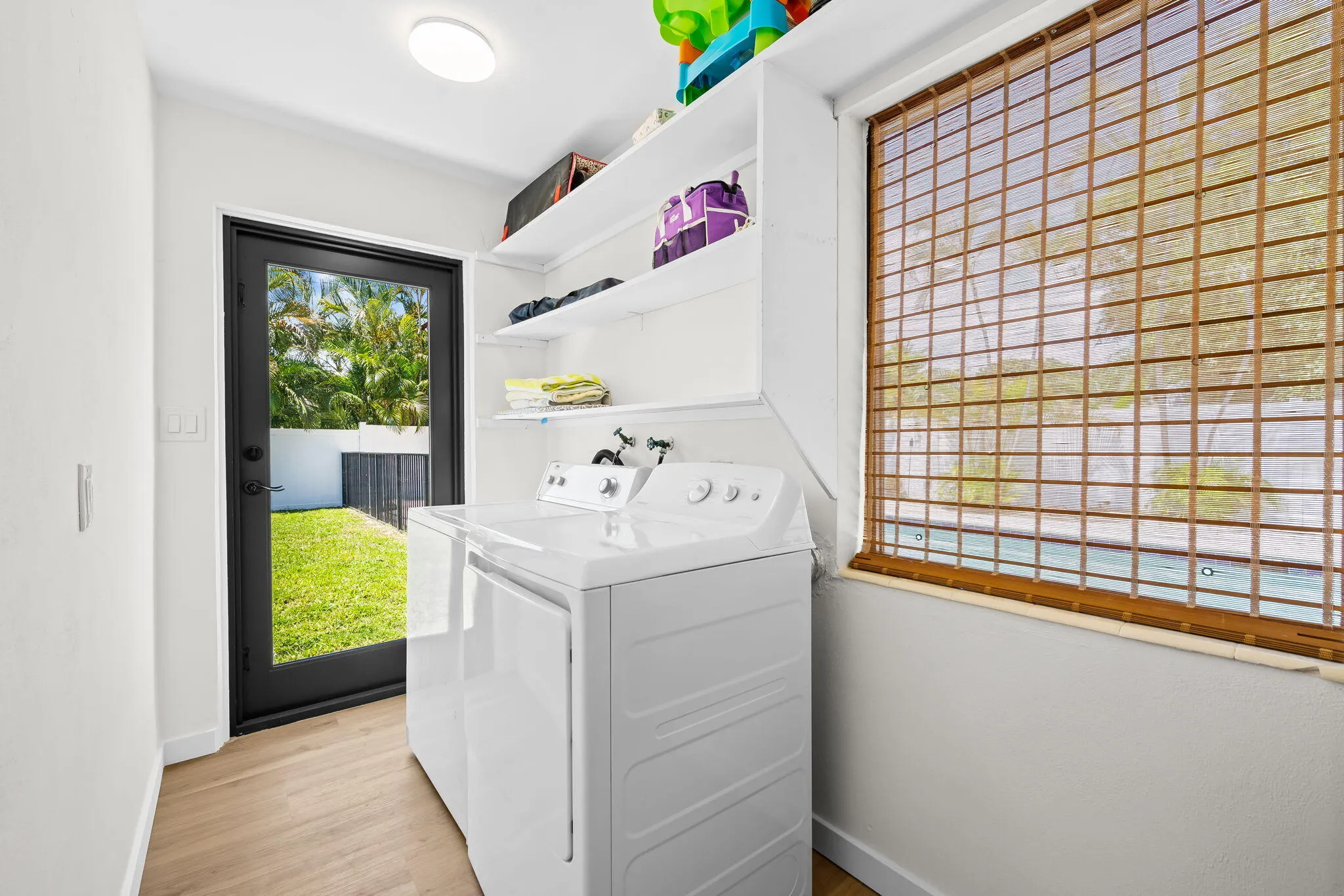 Utility area with wood-finish flooring and white walls