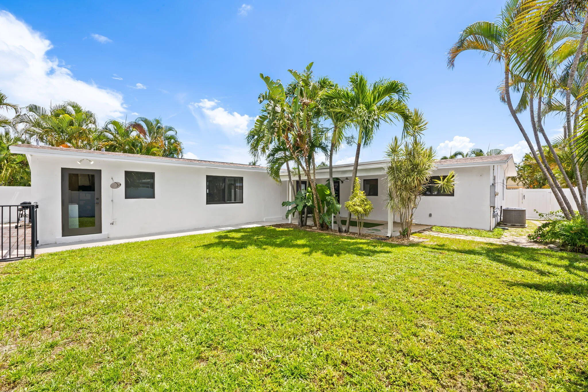 White stucco exterior with dark-framed windows