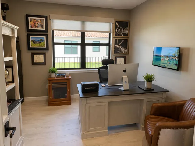 A roomy office/den with huge windows inviting an open and airy feel. Also, remote controlled window treatments