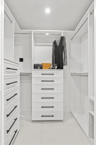 Fully customized cabinetry adorn the his & hers closets providing maximum storage and function.