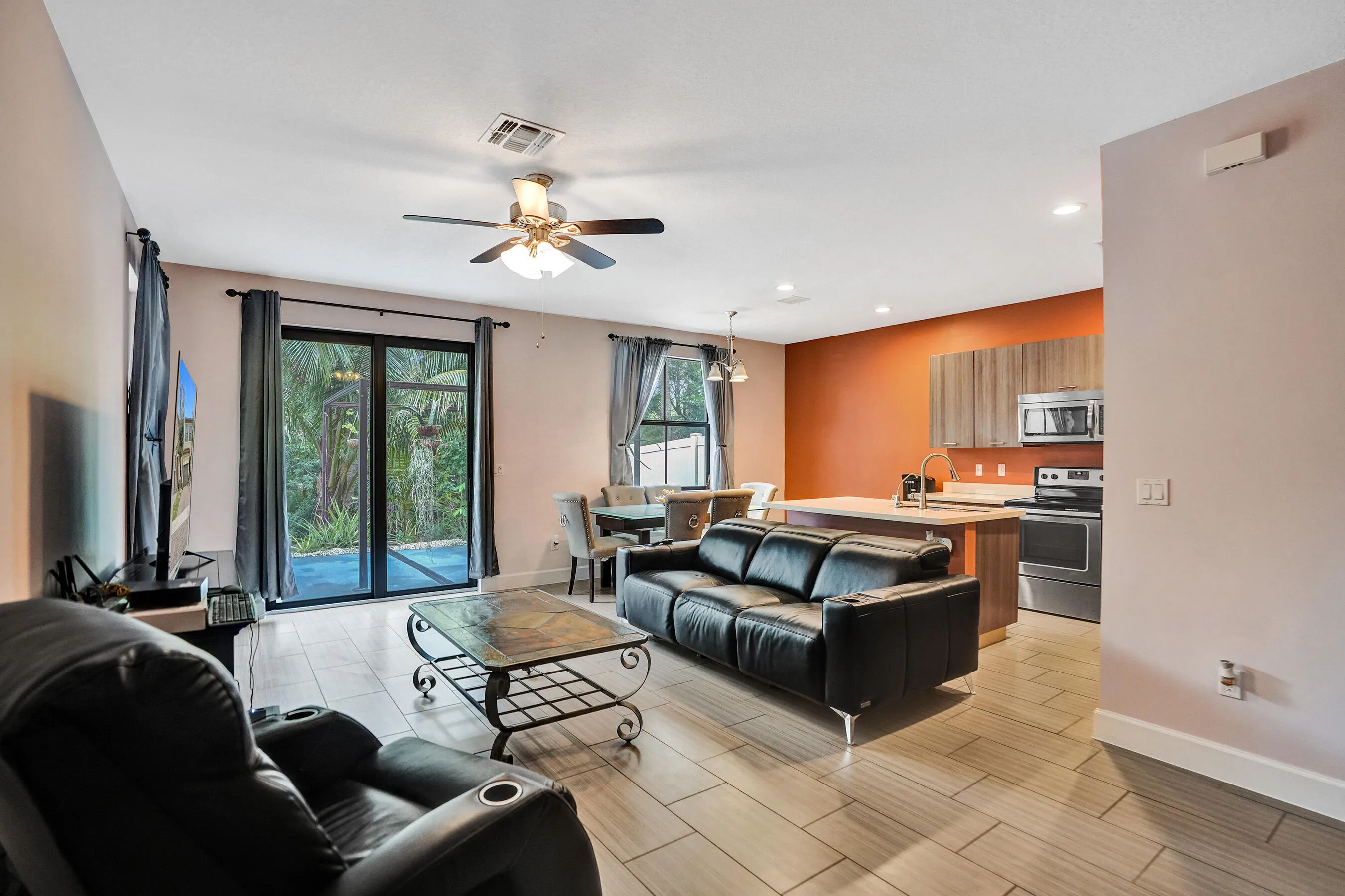 Open concept living space featuring wood-finish flooring, a ceiling fan, and sliding glass doors