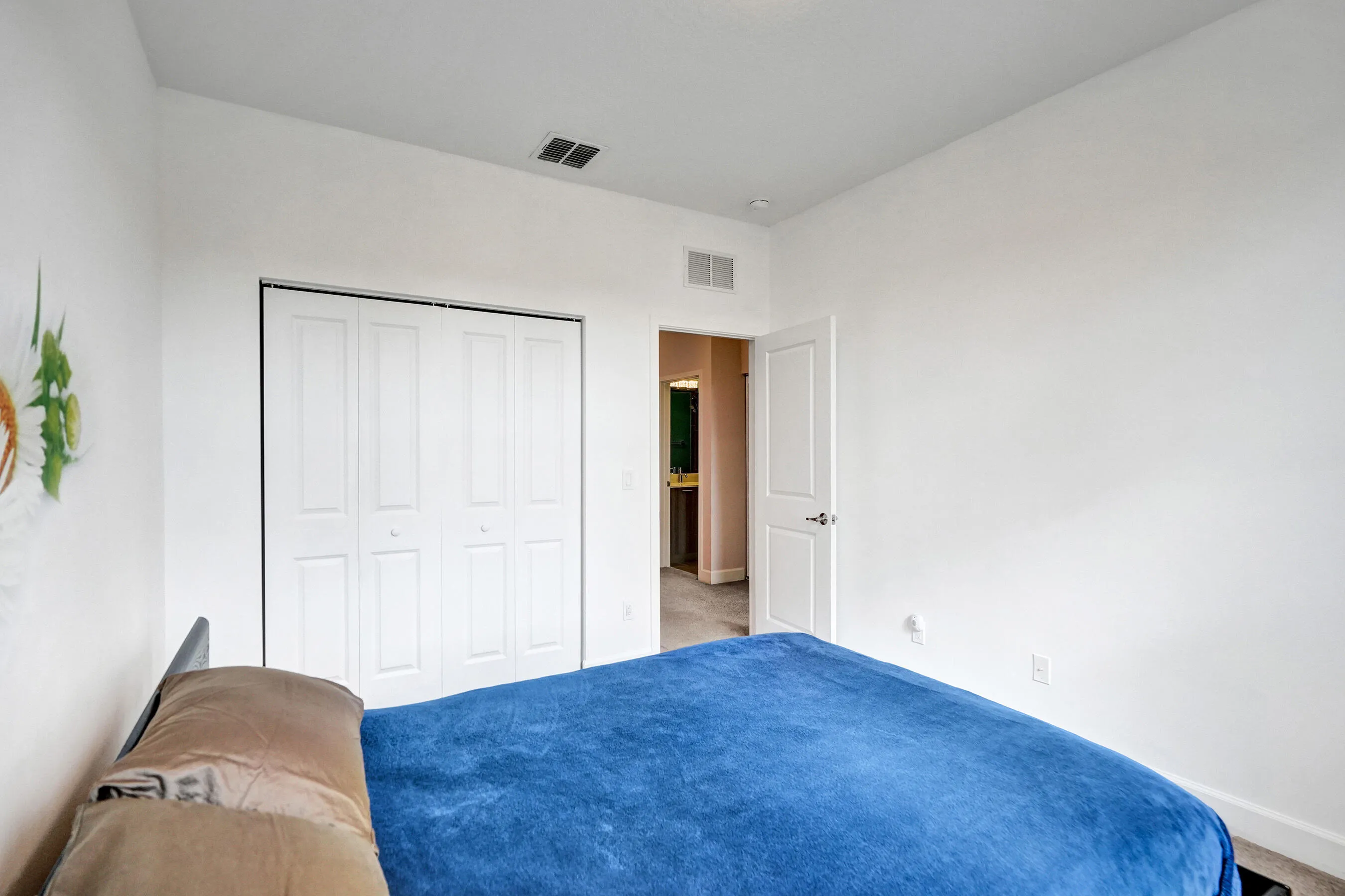 White bi-fold closet doors, white interior door with dark hardware, recessed lighting, and wall-to-wall carpeting
