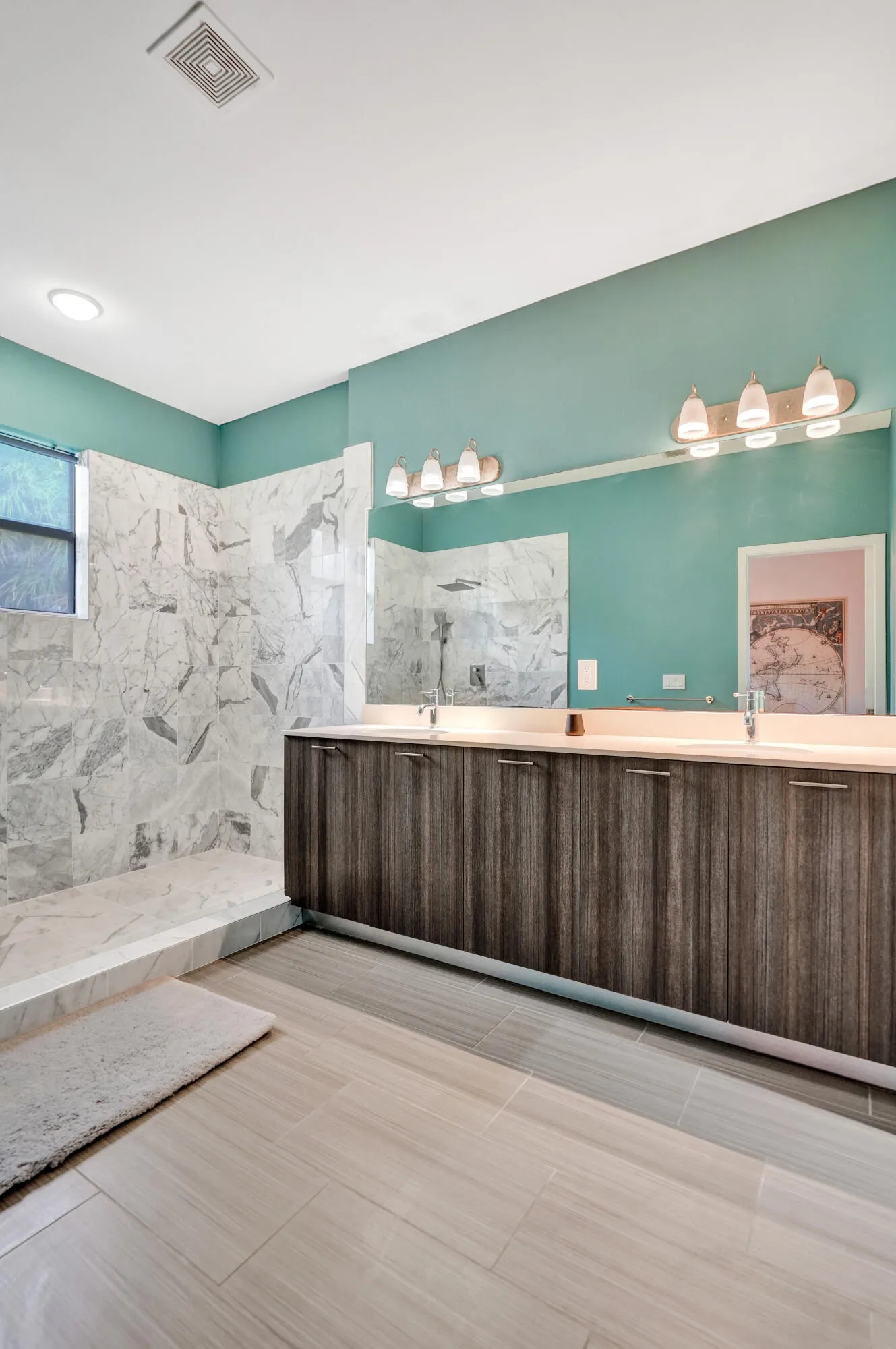 Dual vanity with integrated sinks, wood-finish cabinetry, and a large mirror