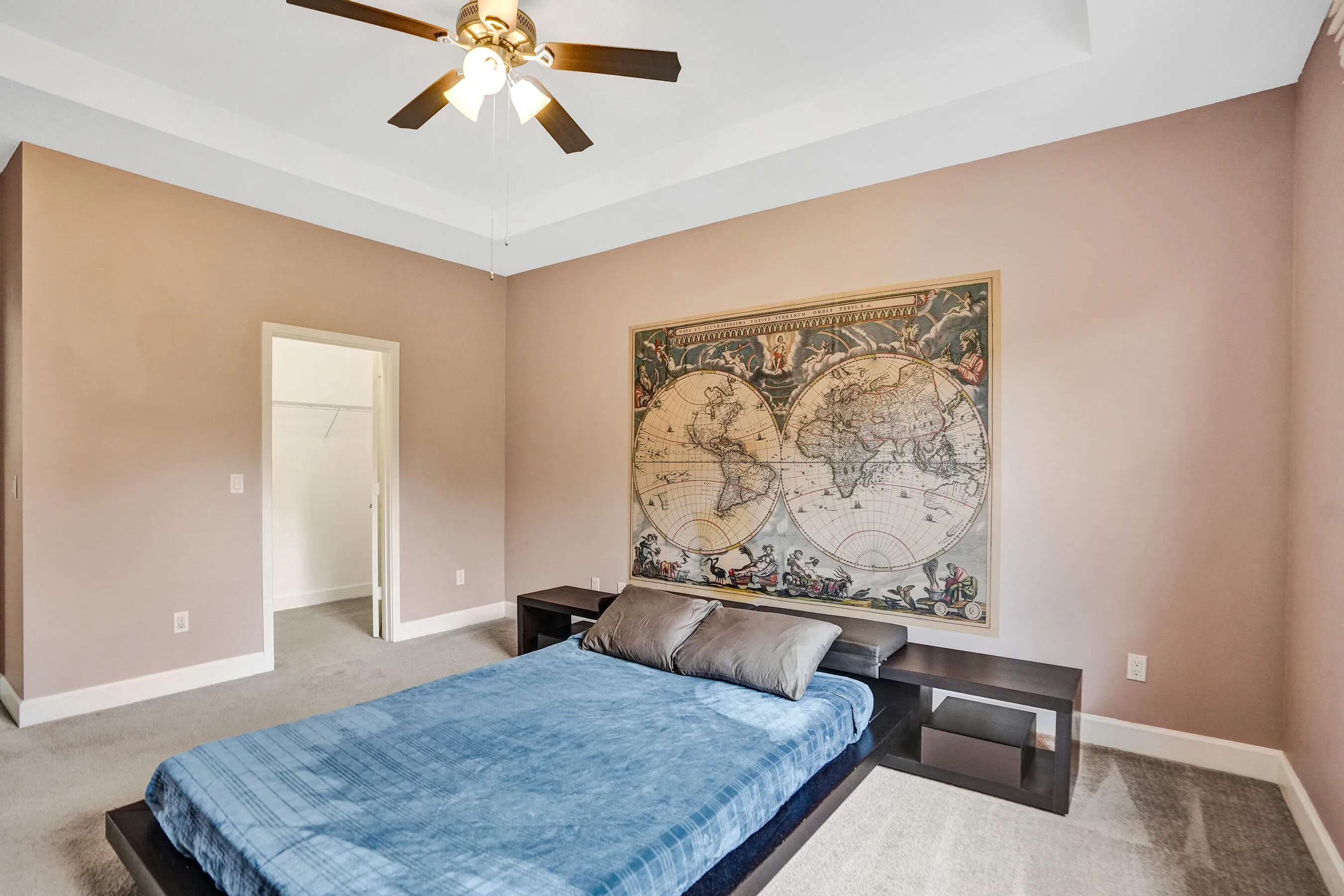 Recessed tray ceiling, ceiling fan with integrated lighting, neutral wall color, white trim, and carpeted flooring