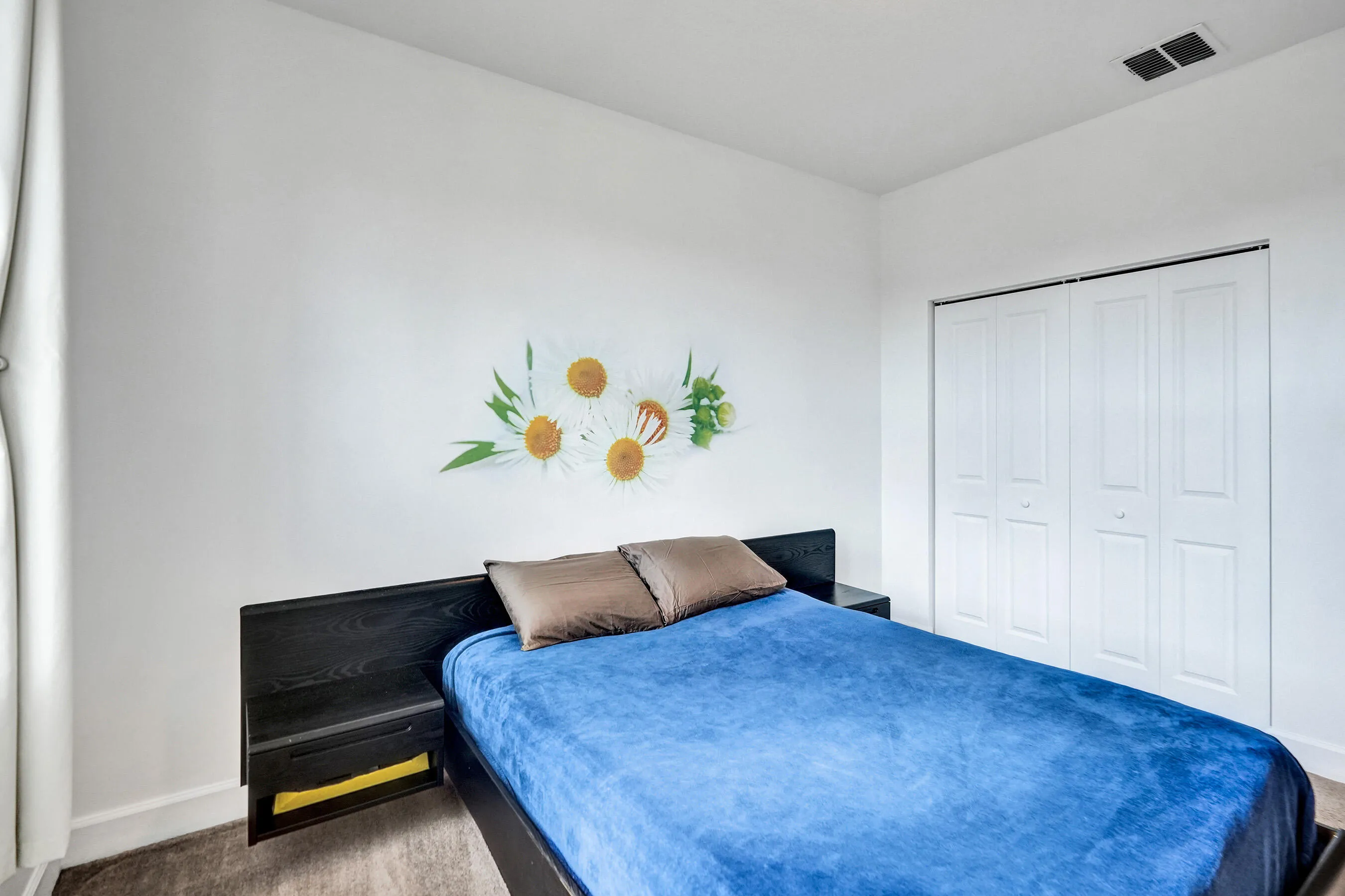 White walls, wood-finish flooring, and white bi-fold closet doors