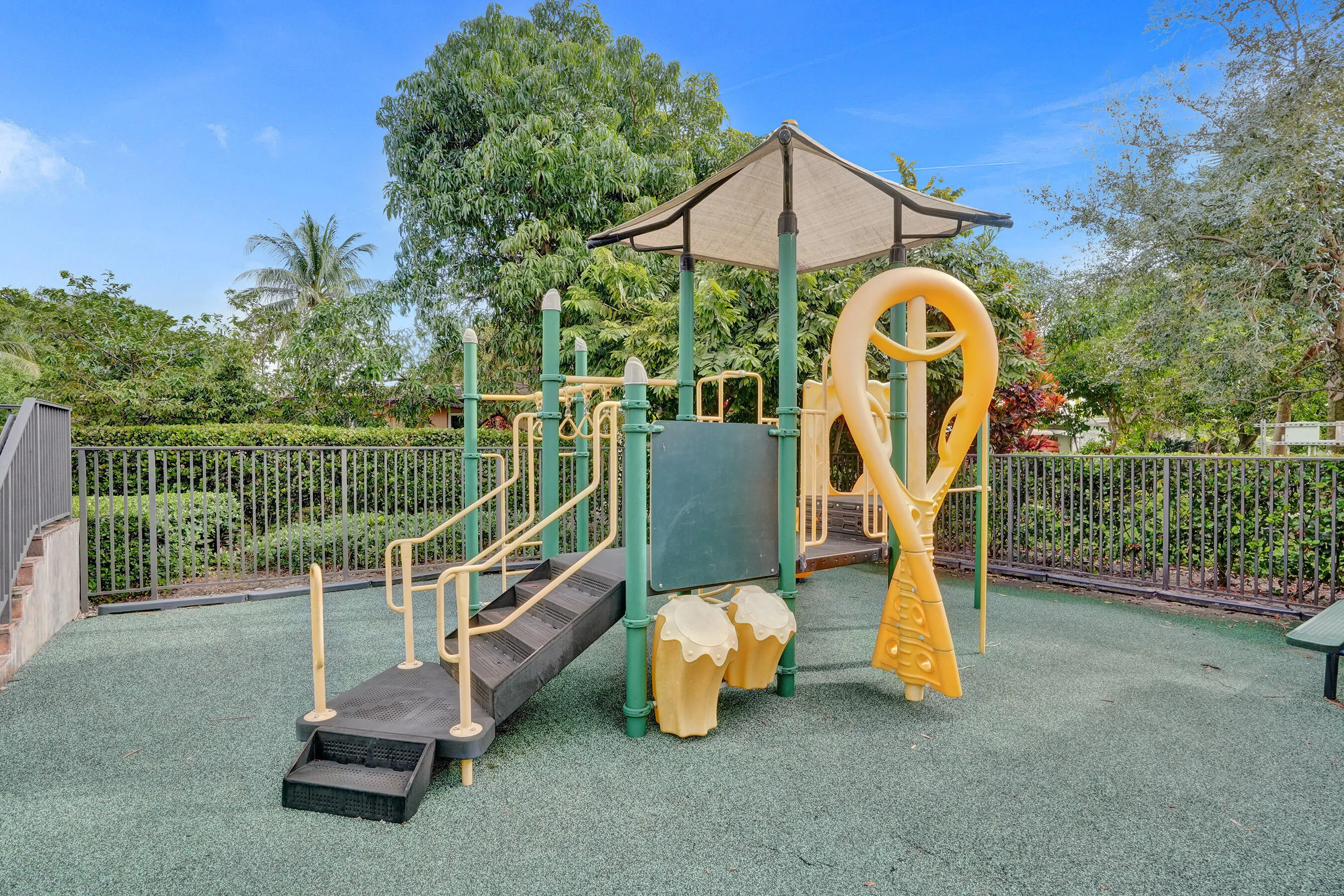 Recreational structure featuring steps, handrails, a covered platform, and a slide component