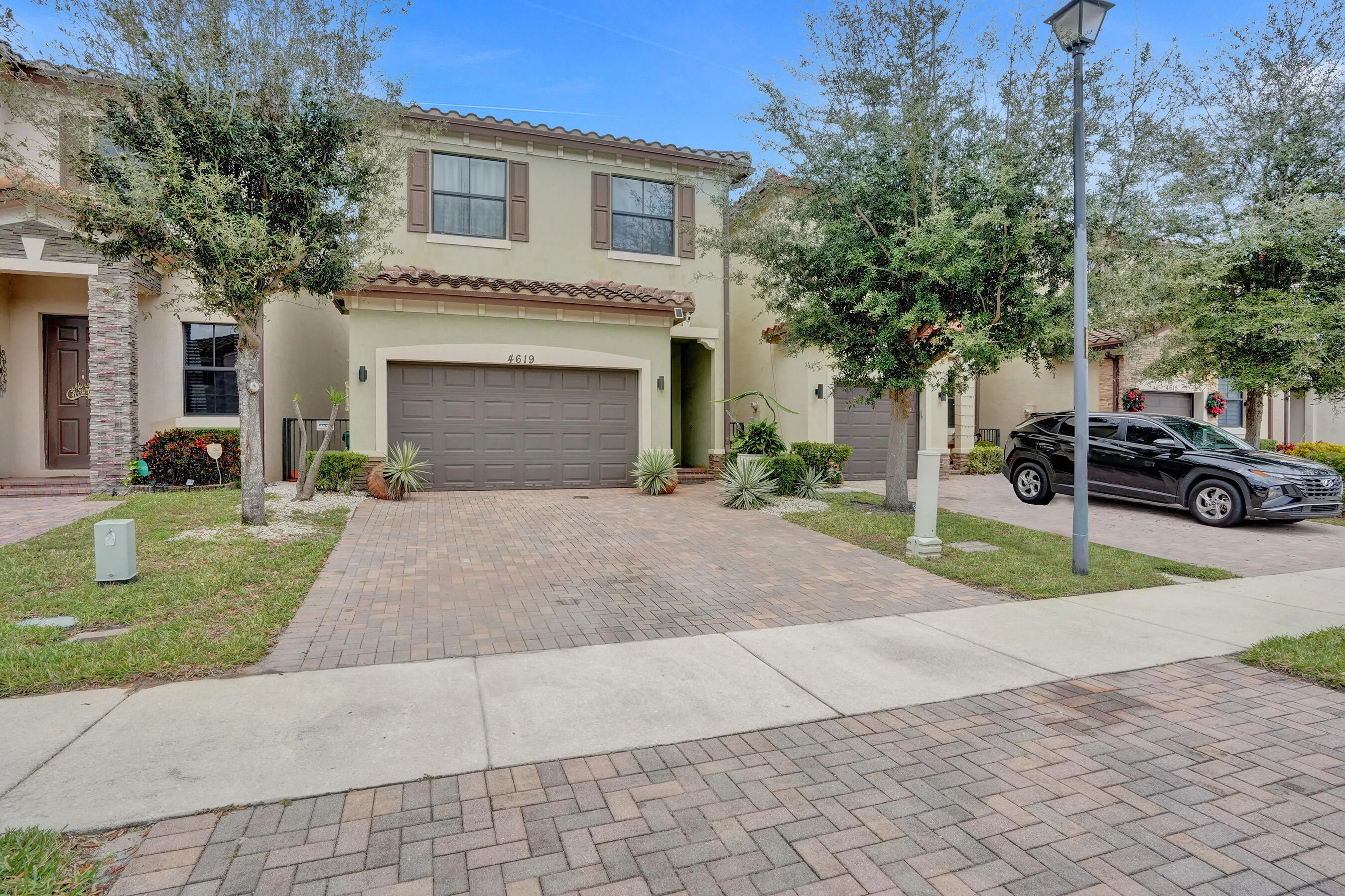 Stucco exterior with a tile roof, decorative shutters, and an integrated garage