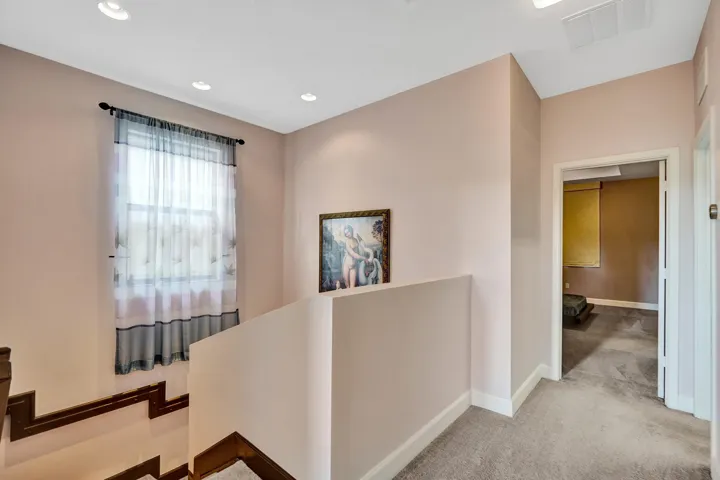Recessed ceiling lighting, carpeted flooring, and white trim details