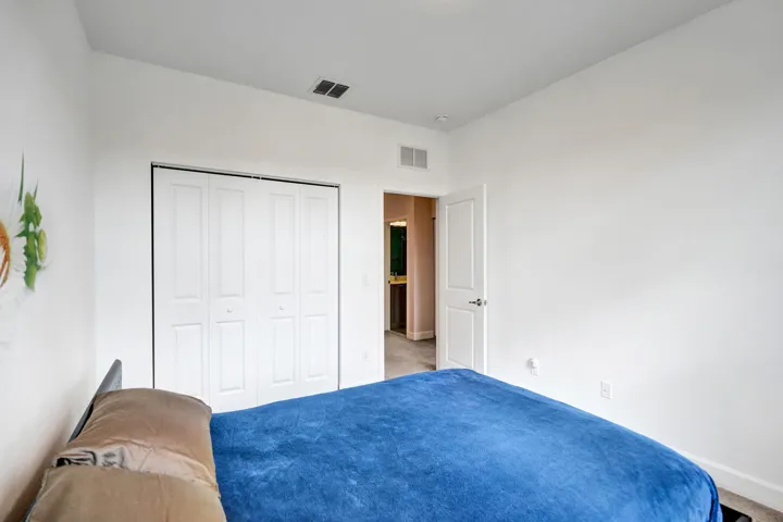 White bi-fold closet doors, white interior door with dark hardware, recessed lighting, and wall-to-wall carpeting
