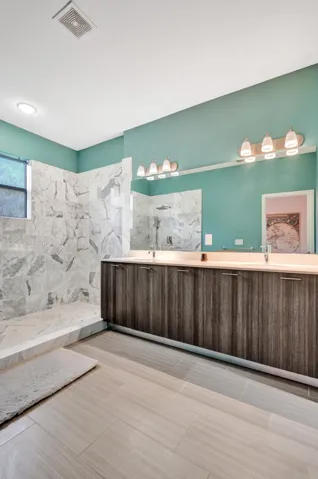 Dual vanity with integrated sinks, wood-finish cabinetry, and a large mirror