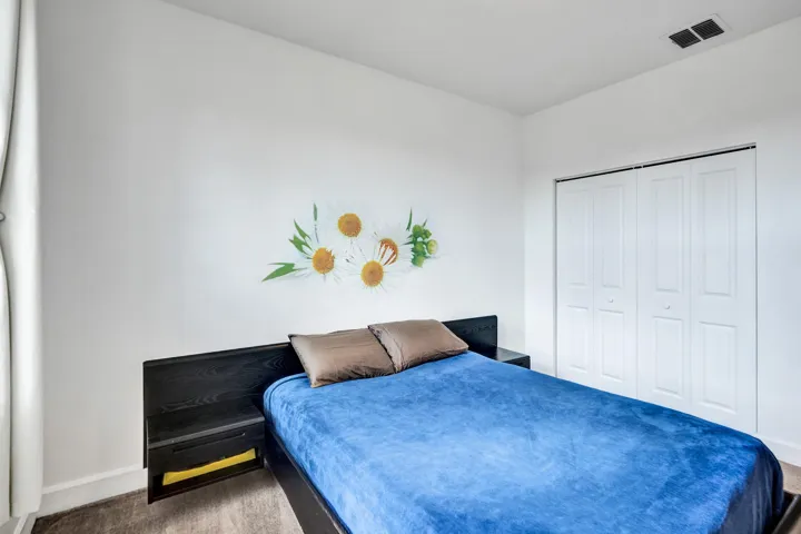 White walls, wood-finish flooring, and white bi-fold closet doors