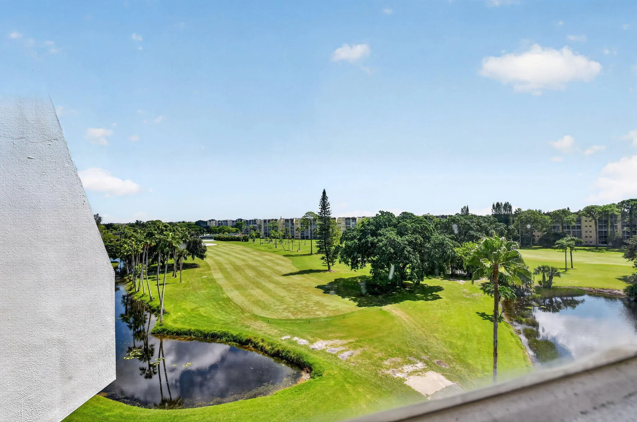 Expansive golf course frontage featuring manicured greens, mature trees, and water features