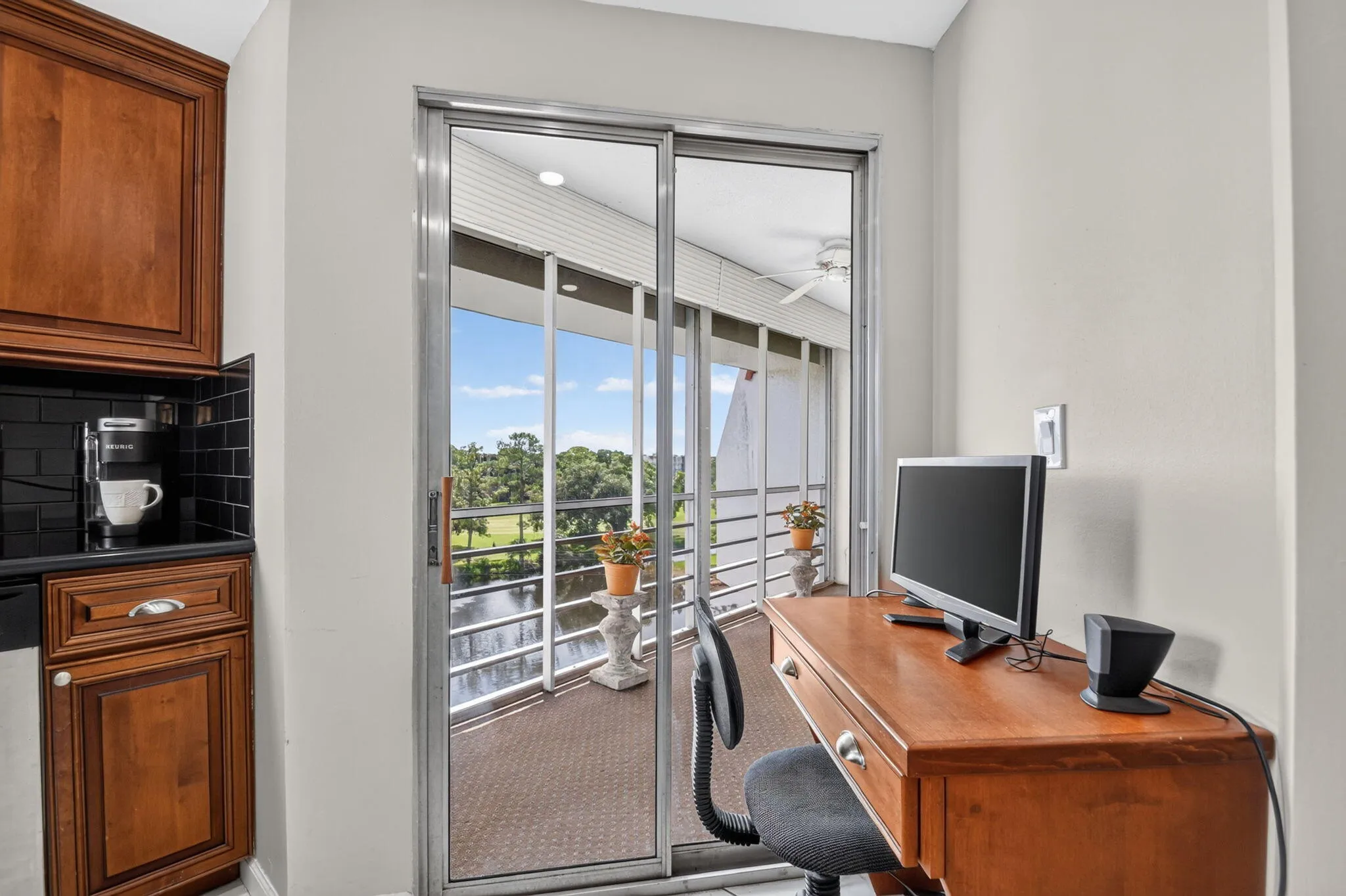 Sliding glass doors opening to a balcony with water and golf course scenery