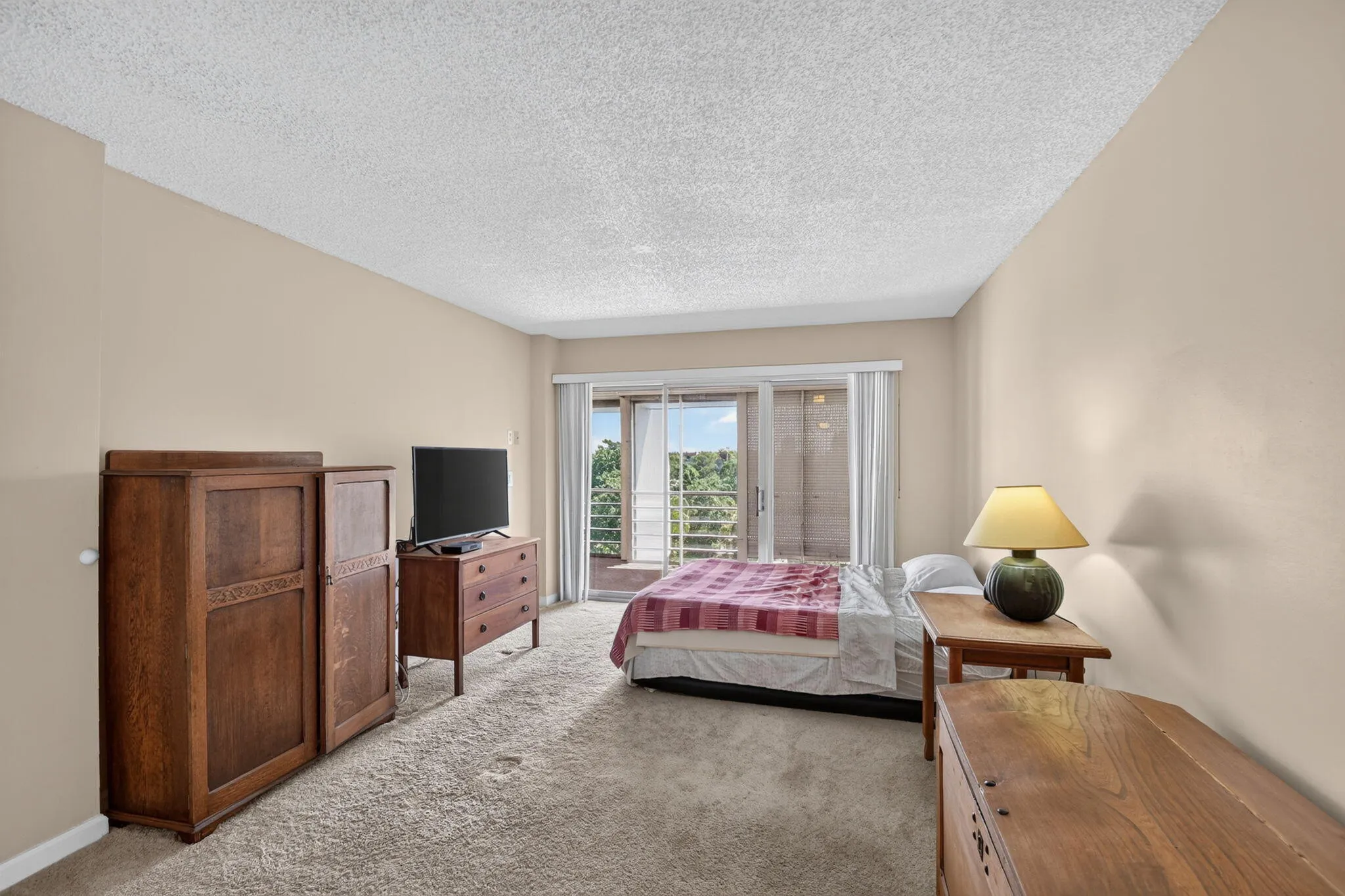 Carpeted room featuring light-toned walls and a sliding glass door