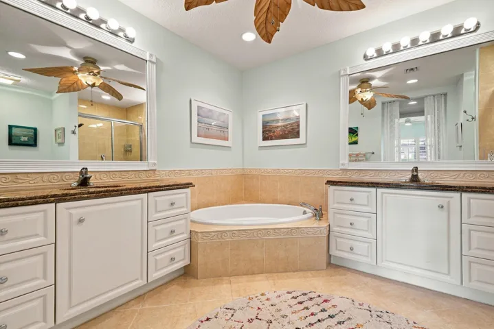 Primary bath with deep soaking tub, separate shower, two walk-in closets, and dual vanities