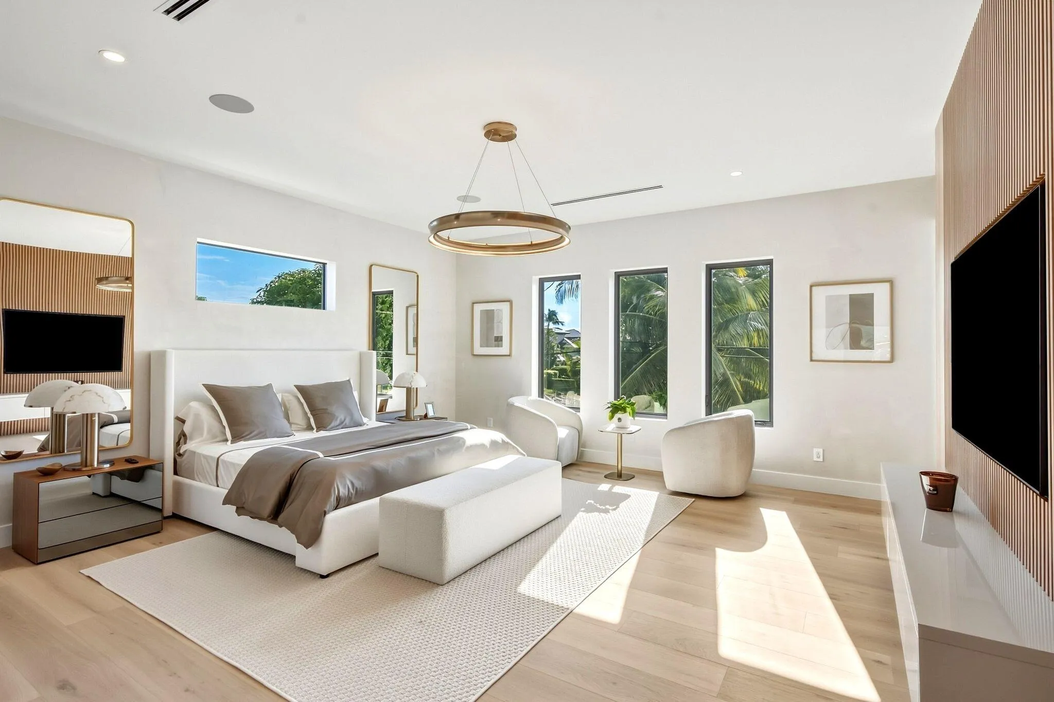 Recessed lighting, light wood-finish flooring, accent wall paneling, multiple windows, and a modern chandelier