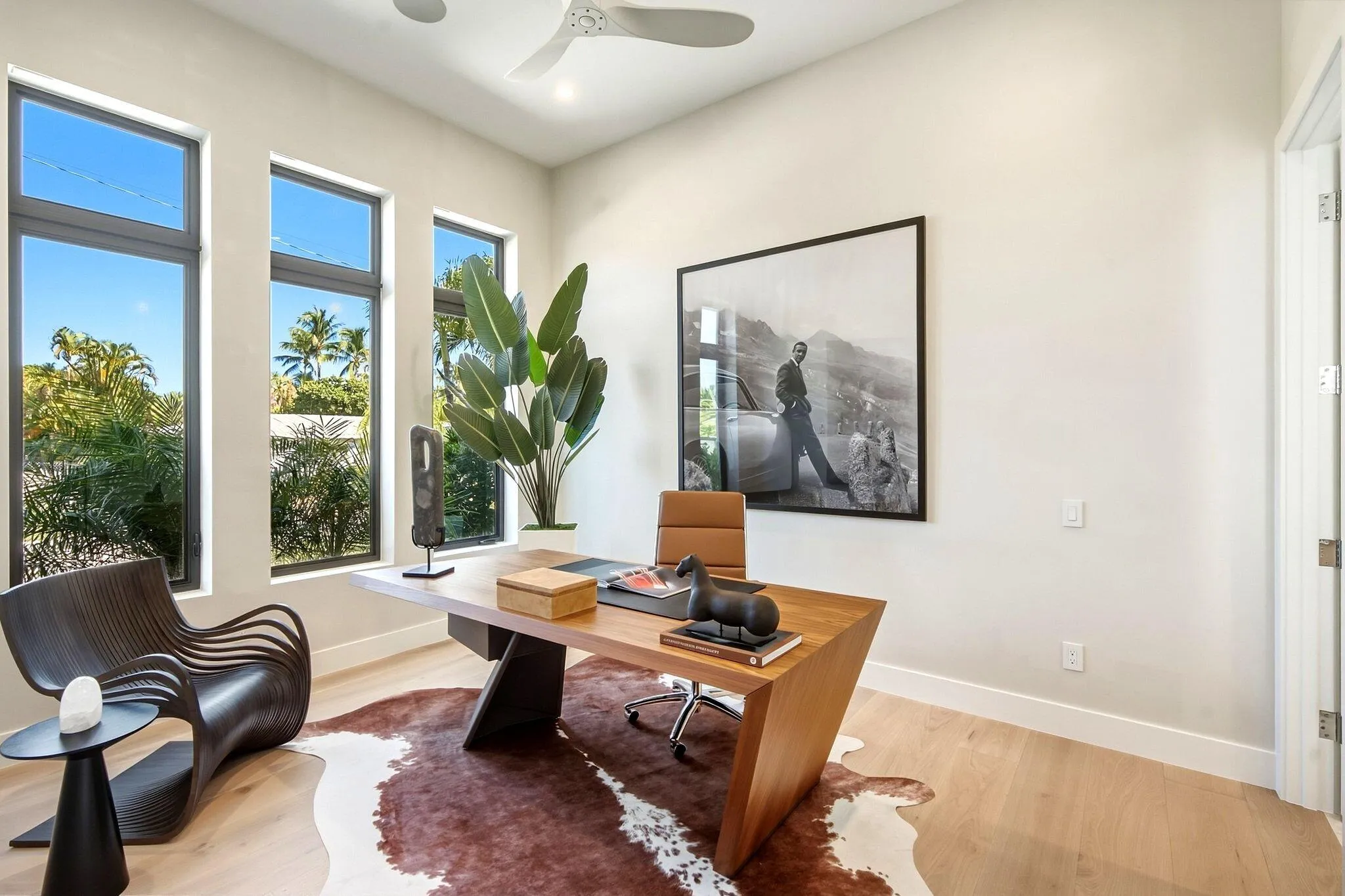 Recessed lighting, wood-finish flooring, a contemporary ceiling fan, and three tall windows