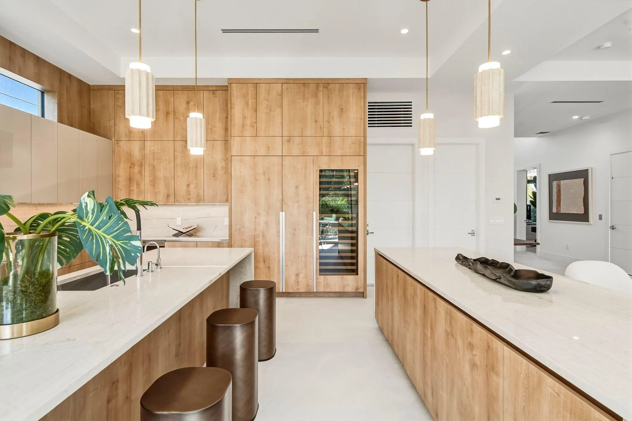 Kitchen featuring wood-finish cabinetry, white countertops, built-in wine refrigeration, and pendant lighting