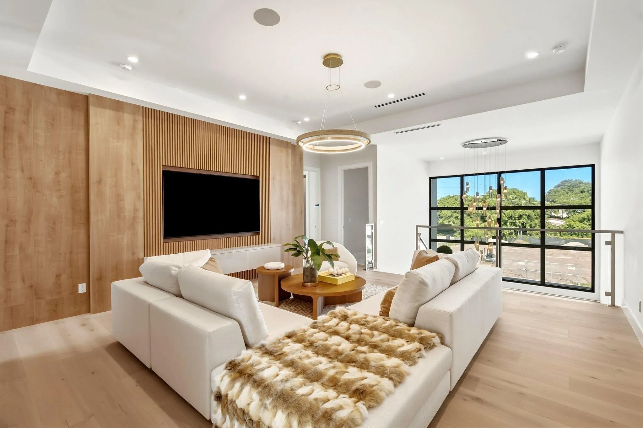 Wood-finish flooring, recessed lighting, and a modern wood accent wall with a built-in media console