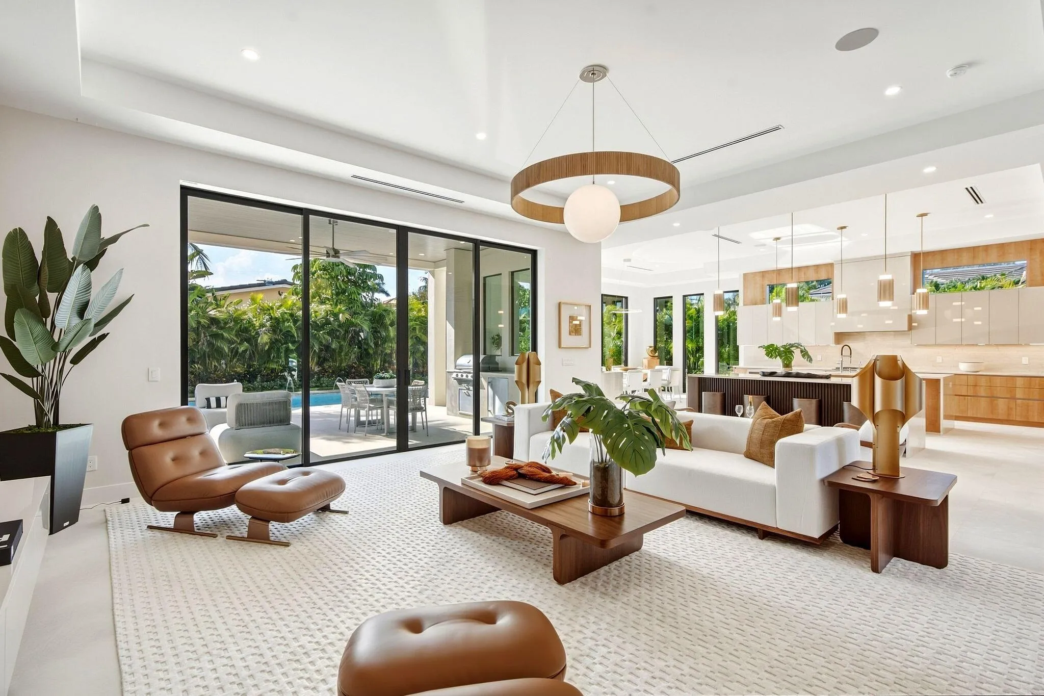 Expansive living area with large format tile flooring, recessed lighting, and a contemporary chandelier