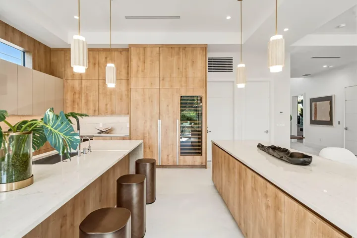 Kitchen featuring wood-finish cabinetry, white countertops, built-in wine refrigeration, and pendant lighting