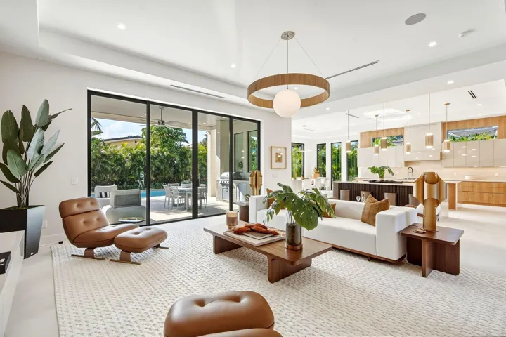 Expansive living area with large format tile flooring, recessed lighting, and a contemporary chandelier