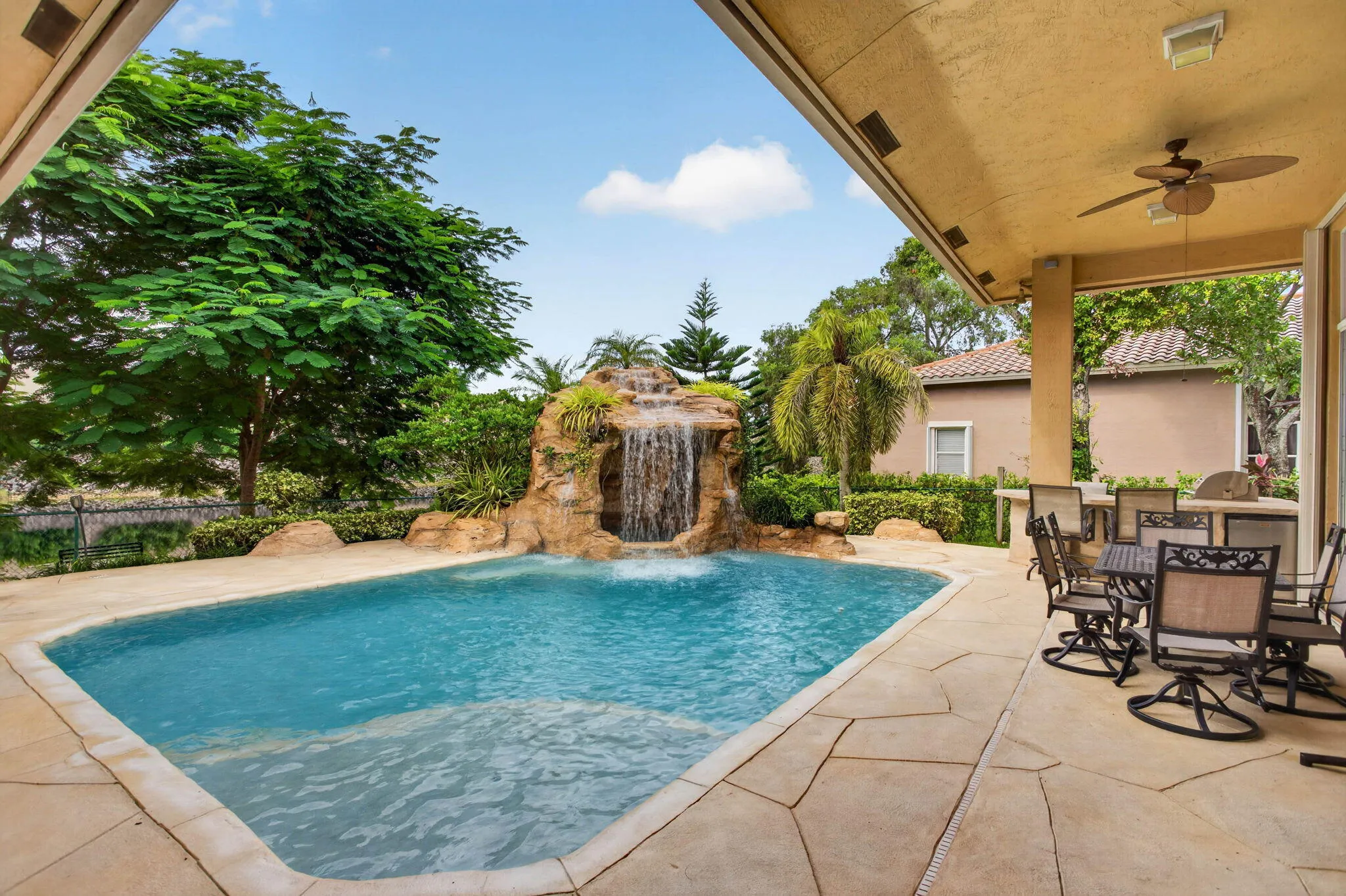 Pool deck. View from bay window living room area. Looking towards the waterfall and BBQ areas.