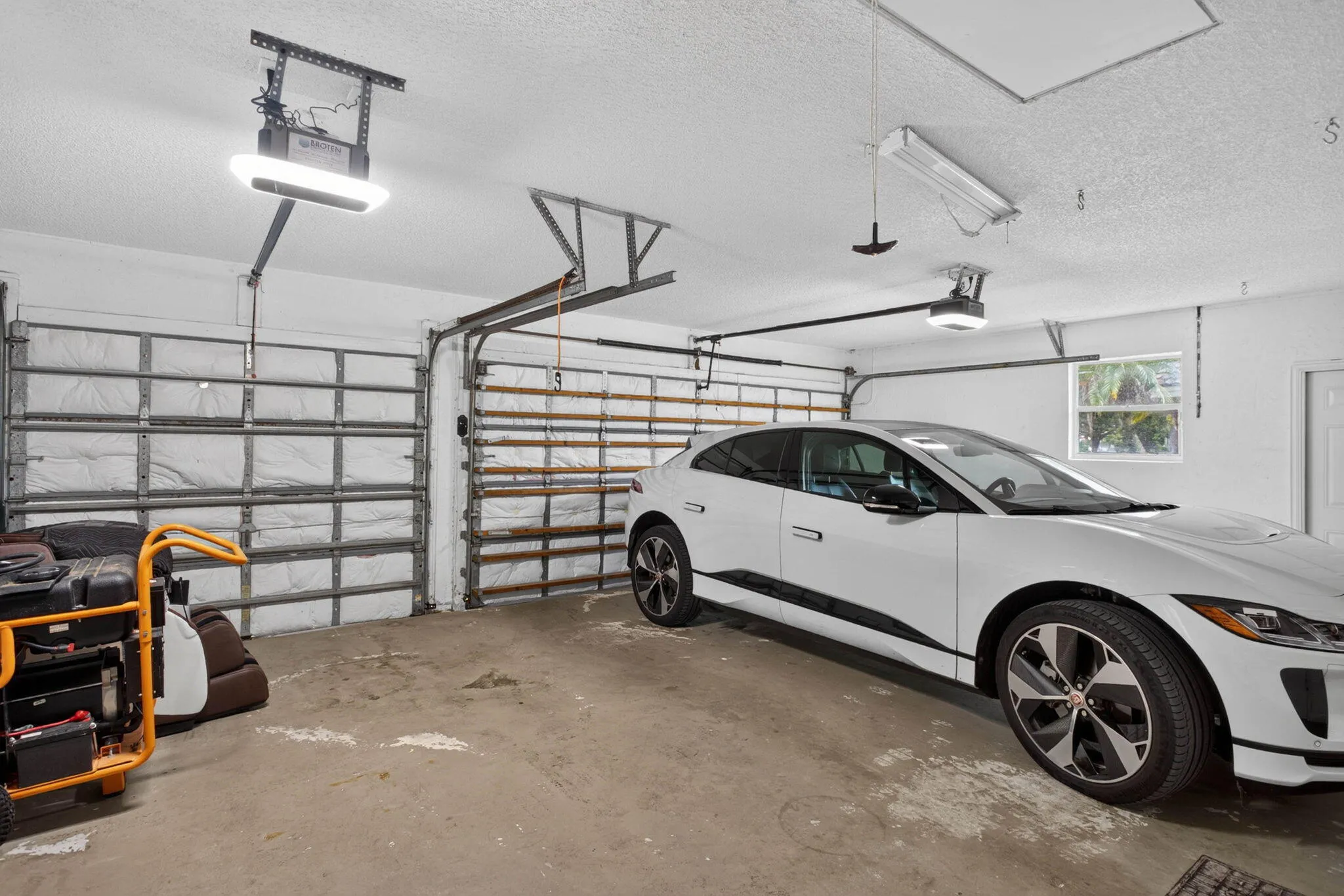 Three car garage. Note this garage is equipped with Broten garage door openers featuring App linked video recording and automatic door closing set for five minutes. The garage is also equipped with a EV car charging port with twenty five foot cord for back in parking if needed.