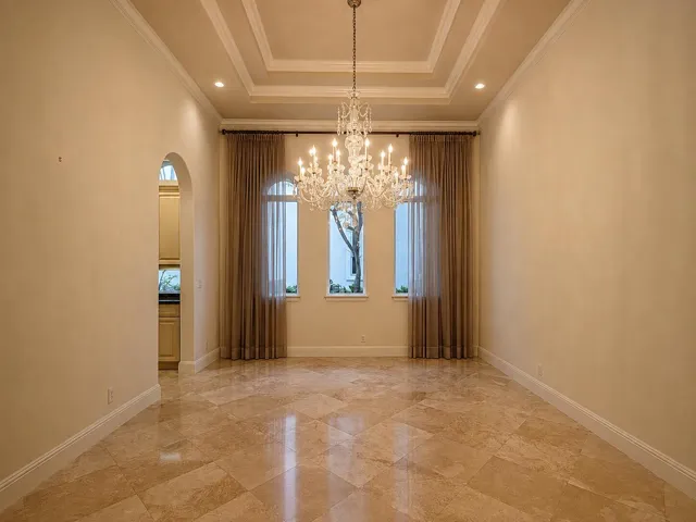 Tray ceiling with recessed lighting and a crystal chandelier