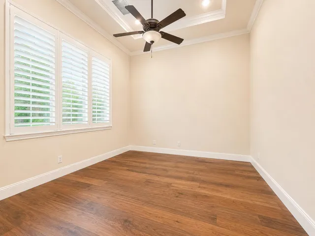 Tray ceiling with recessed lighting, wood-finish flooring, and crown molding