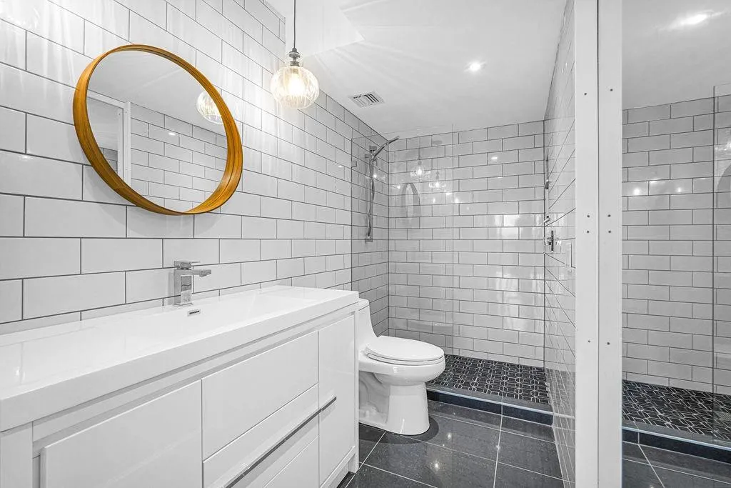 Chic white tile bathroom with step-in glass enclosed shower