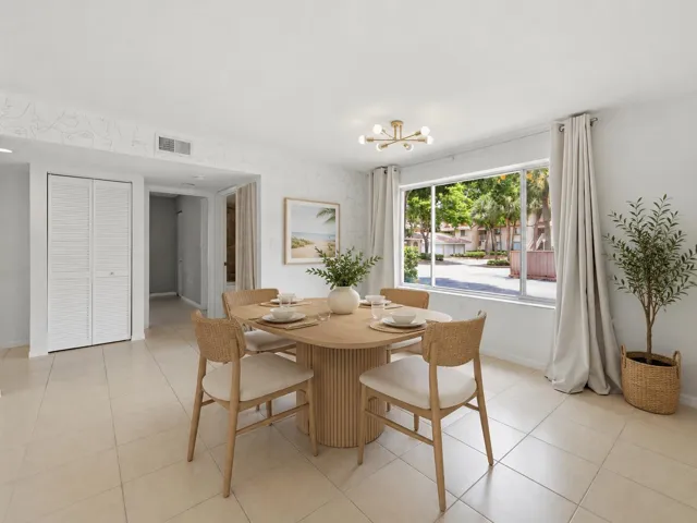 Bright living space featuring large format tile flooring, a modern sputnik light fixture, and a wide window with exterior landscaping.