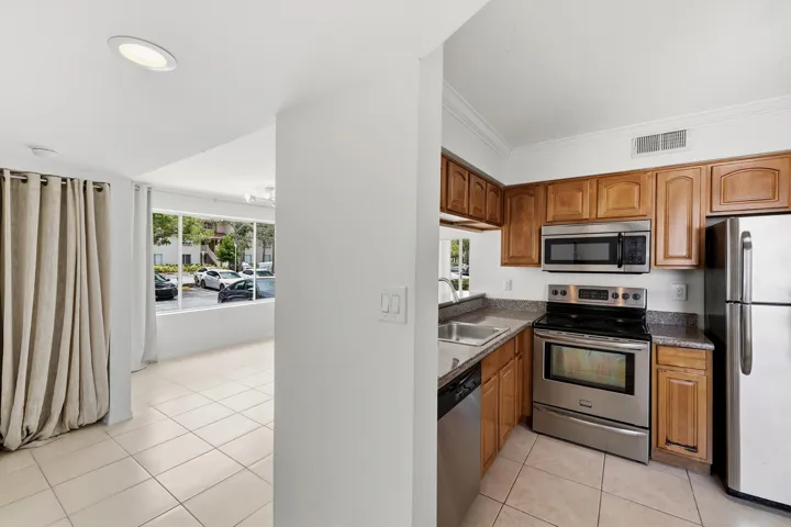 Kitchen featuring wood cabinetry, stainless steel appliances, and granite countertops