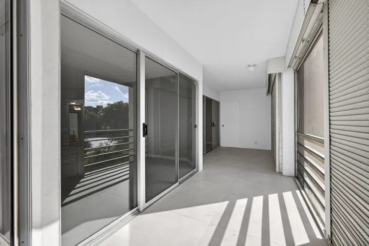 View of balcony area from kitchen showing entry to living room (closest) and master bedroom far end