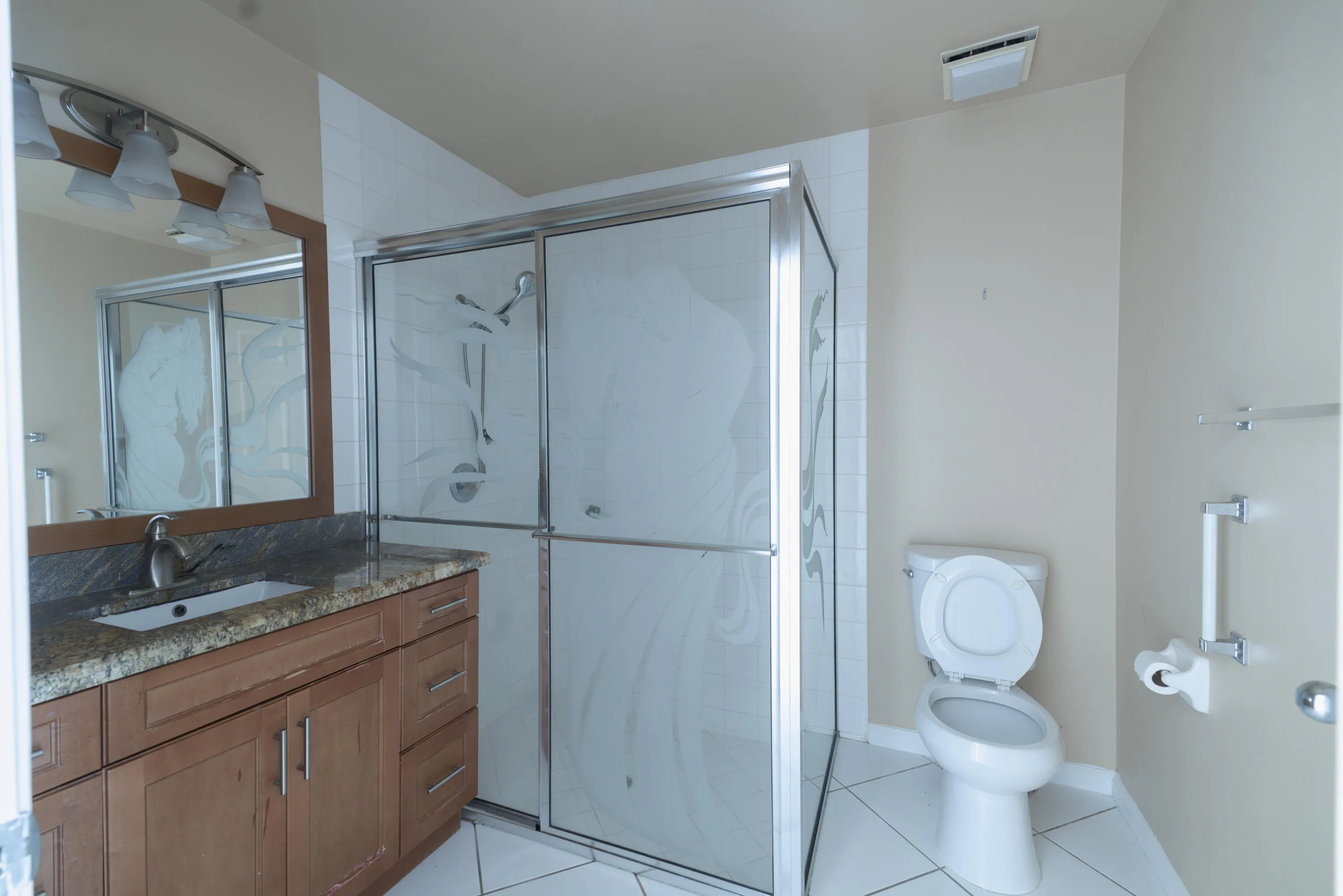 Wood-finish vanity with a granite countertop and undermount sink