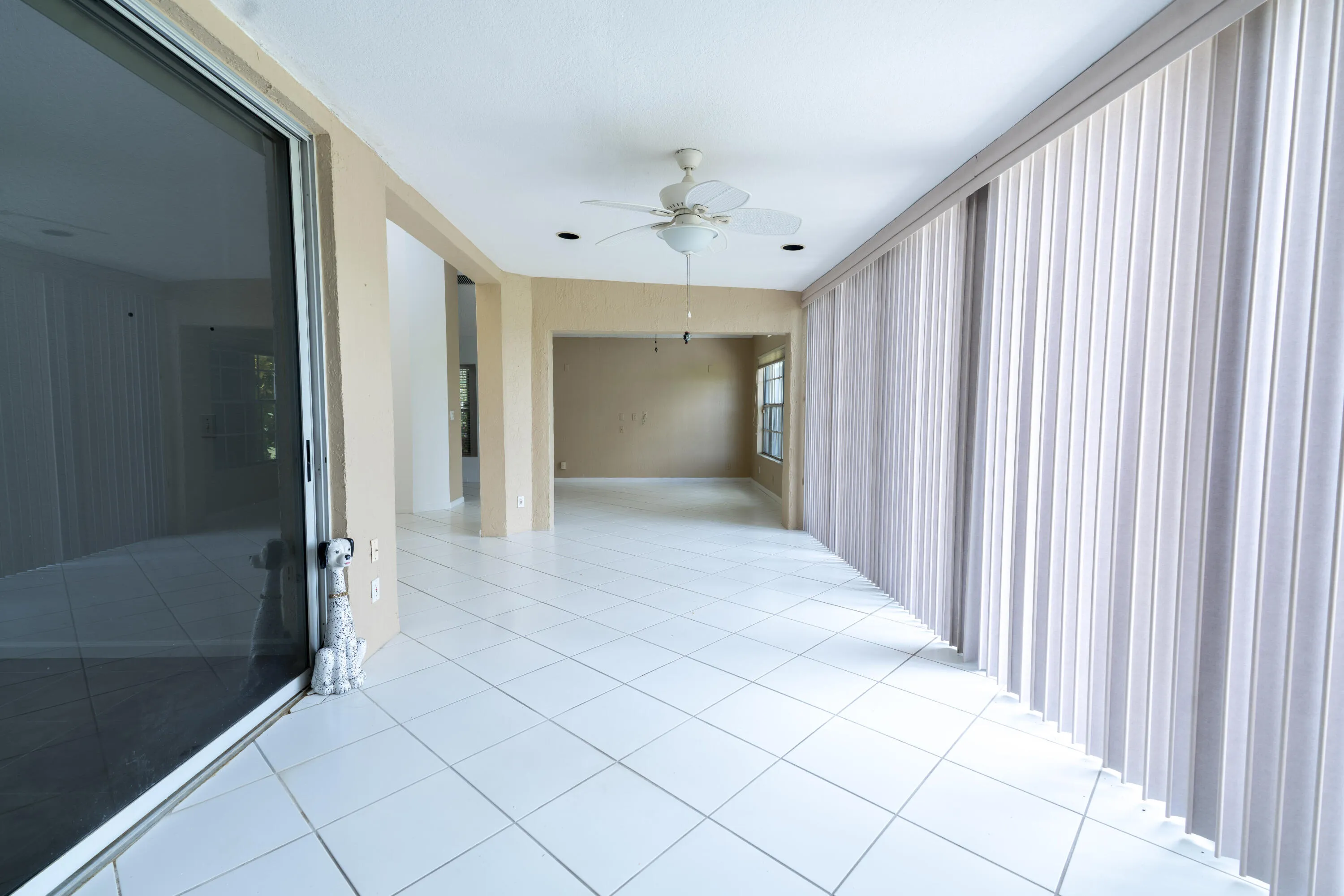 Expansive interior space featuring light-toned tile flooring, recessed lighting, and a ceiling fan