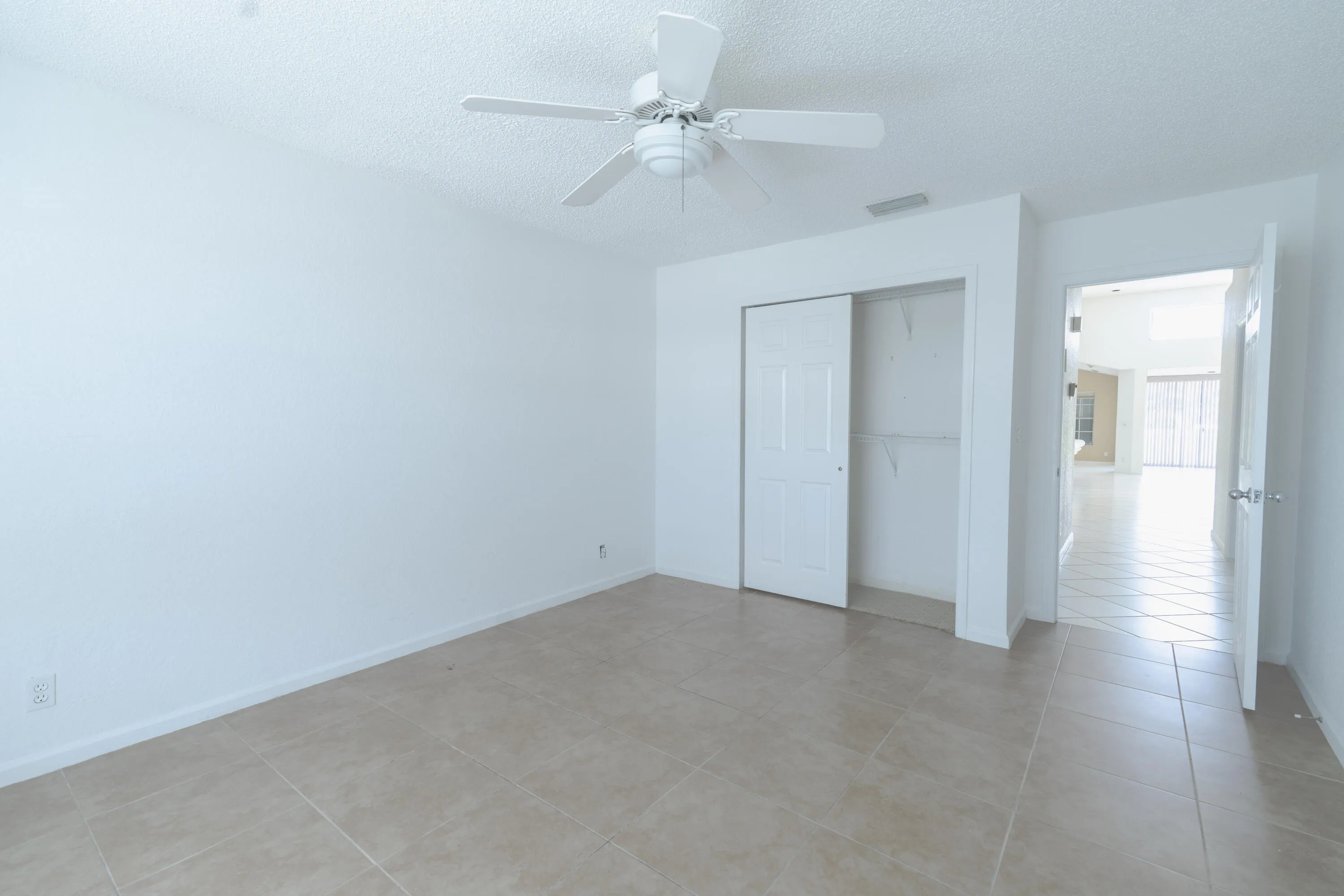 Tile flooring, ceiling fan, and white walls