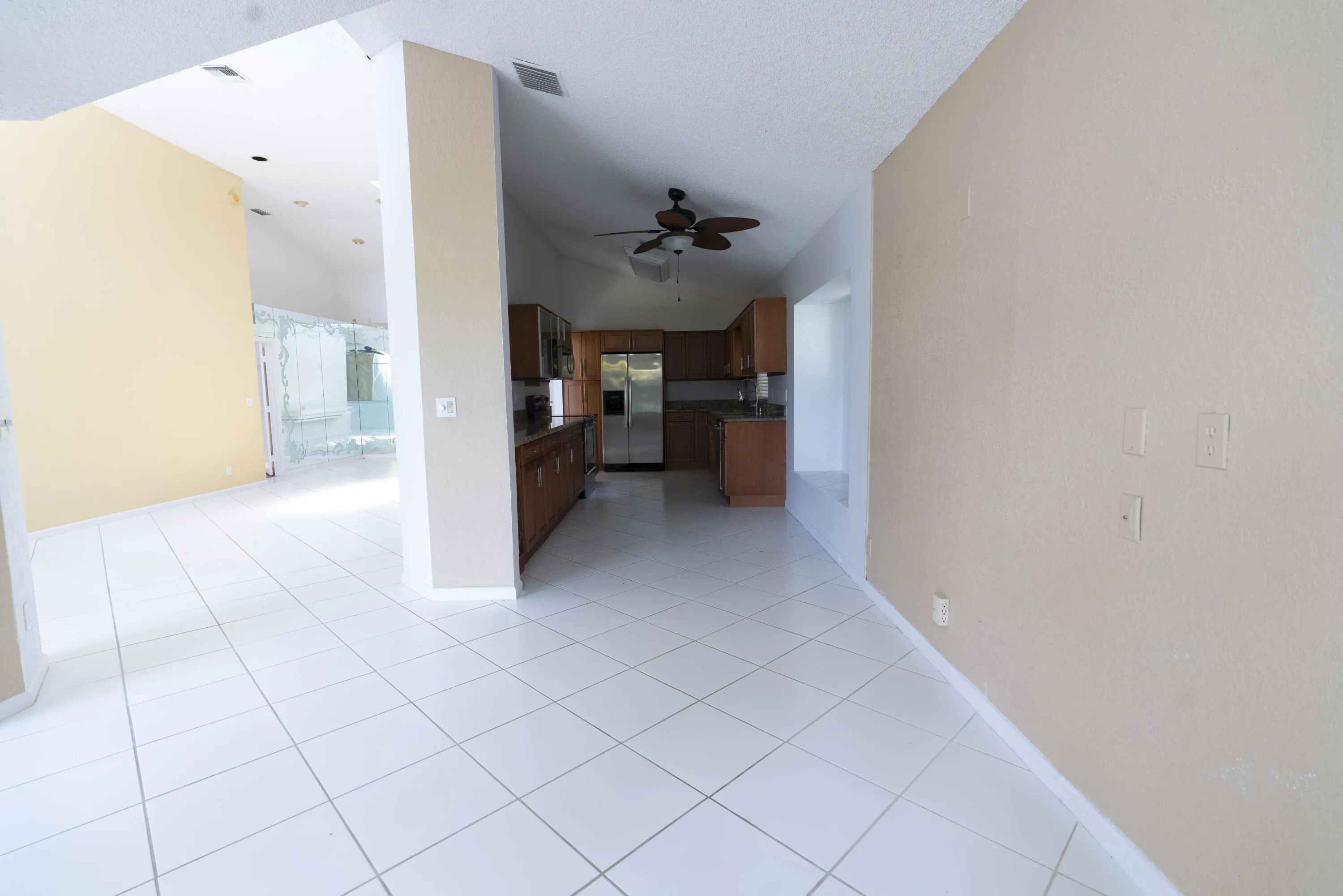 Open concept interior featuring vaulted ceilings and white tile flooring