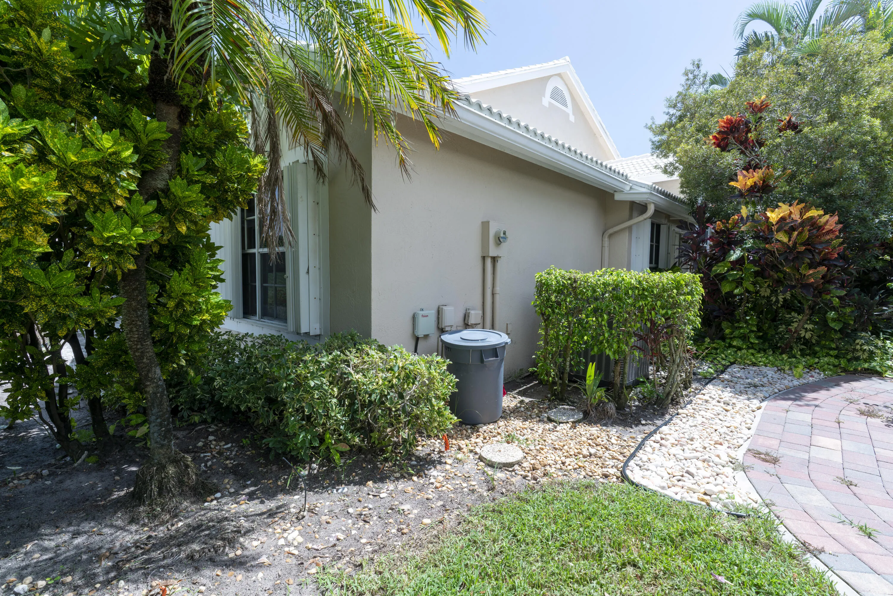 Exterior stucco siding with a gabled roofline and white gutters