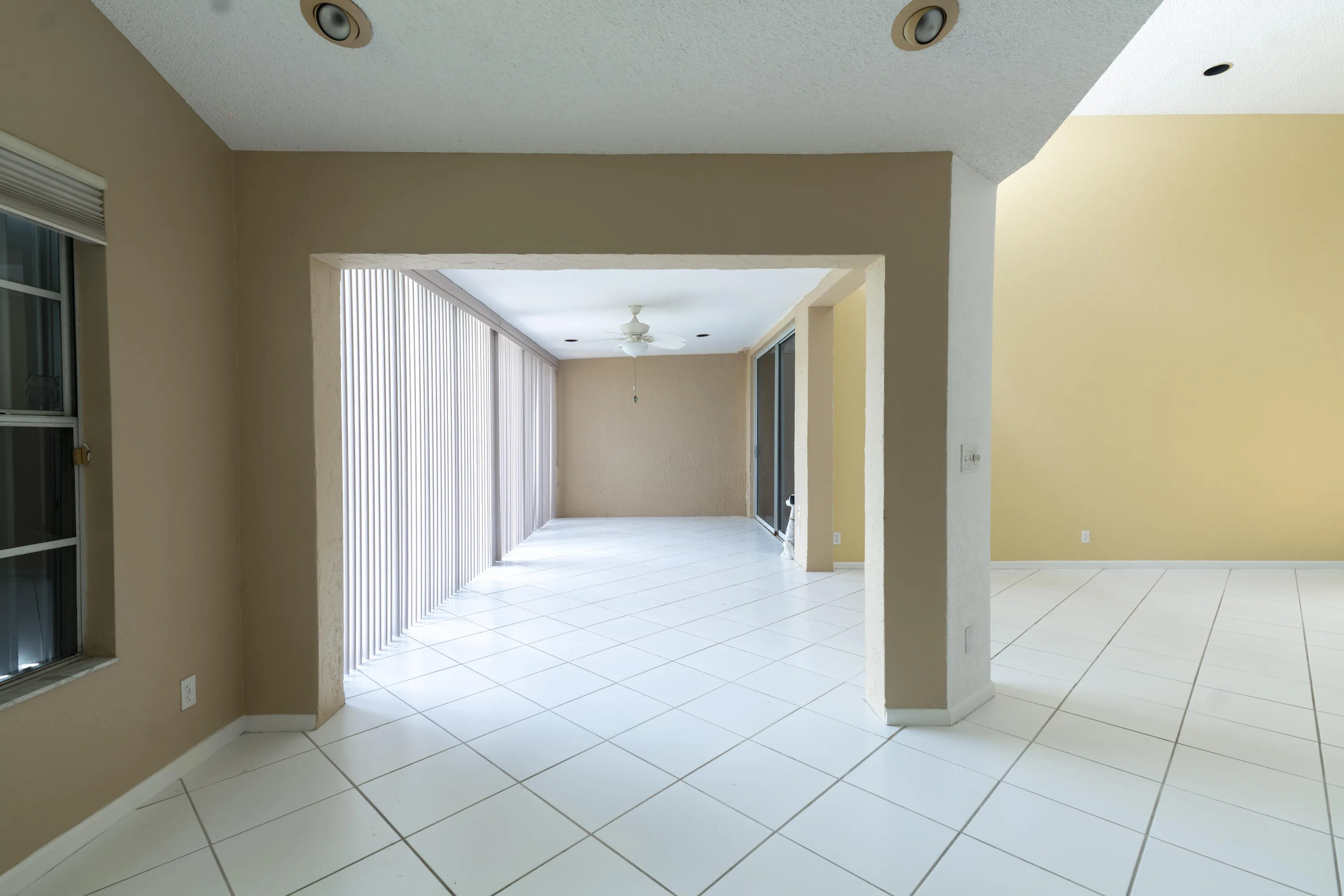 White tiled flooring, recessed ceiling lighting, vaulted ceiling, and vertical blinds